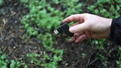 While exploring the woods, someone stumbles upon a muddy USB stick—later discove Stock Footage 307142558