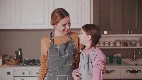 While making a cake, Mom jokingly smears her daughter's nose with cream. Stock Footage 234186002