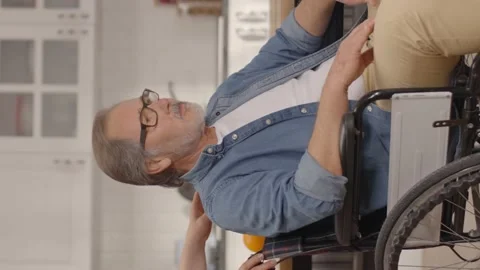 While the old man sitting in a wheelchair in his house looks outside. Stock Footage 151998092