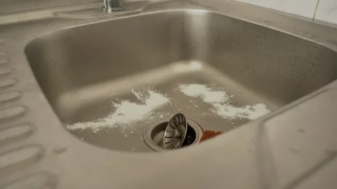 While washing dishes in the kitchen, a man cleans shiny metal utensils Video stock 302347618