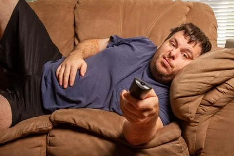 While watching TV this man does not look happy Stock Photos