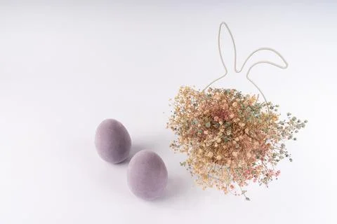 Whimsical Easter display with soft purple flocked eggs and a charming dried.. Stock Photos