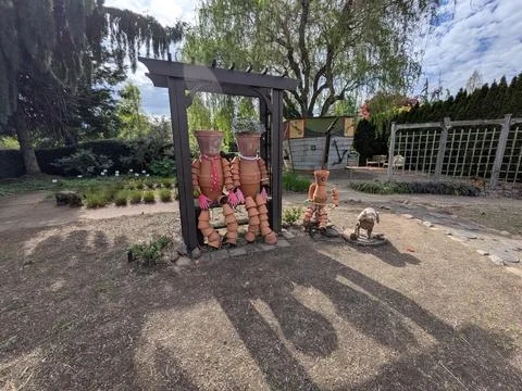 Whimsical garden display featuring creative flowerpot people seated on a bench Stock-Fotos