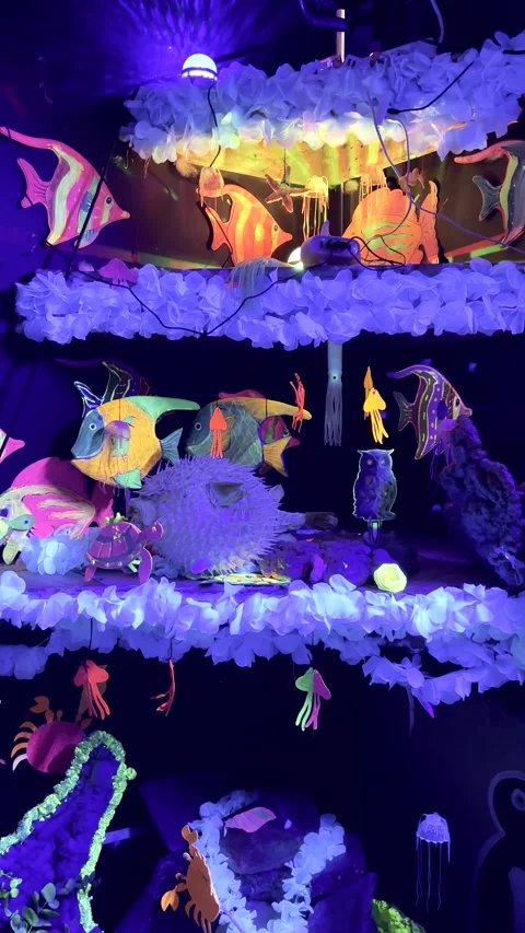 Whimsical illuminated creatures in room with fluorescent lighting Stock Footage 345620796