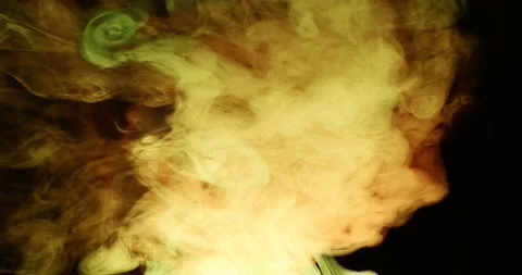 Whimsical movement of colored puffs of smoke against a dark background. 库存影片 146530466