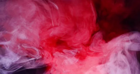 Whimsical movement of colored puffs of smoke against a dark background. 库存影片 146534738