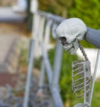Whimsical Skeleton Hanging on Railing Stock Photos