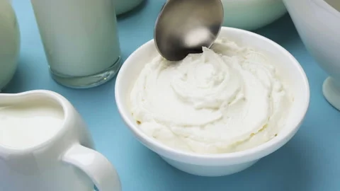 Whipped cream with spoon on blue background, top view Video stock 147647610