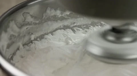 Whipped egg whites for cream with mixer in iron bowl, slow motion, closeup Stock Footage 62425657