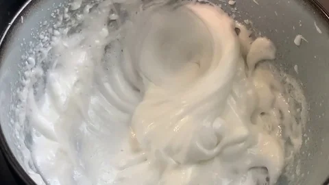 Whipping egg whites to create a thick and frothy consistency. Stock Footage 130106855