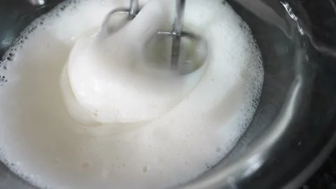 Whipping egg whites with sugar using an electric mixer for dessert Stock Footage 148374702