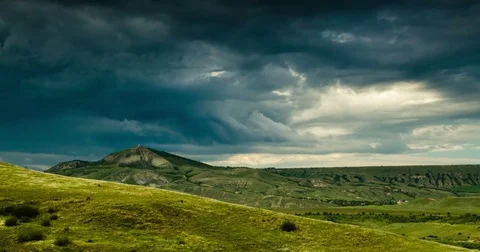 A whirlwind of dark clouds over green hills Stock Footage 76455818