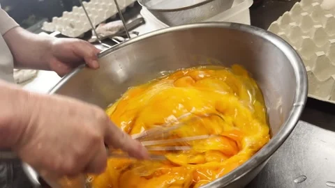 Whisk Mixing Many Orange Egg Yolks in a Steel Bowl (Dashimaki Omelette), Japan Stock Footage 340752144