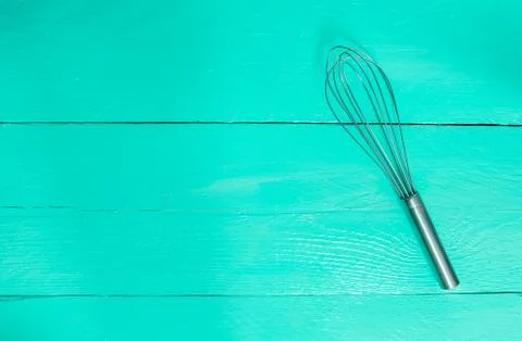 Whisk on turquoise wood as background Stock Photos