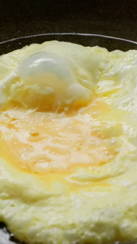 Whisked beaten eggs fried in an iron wok pan. Stock Footage 337450861