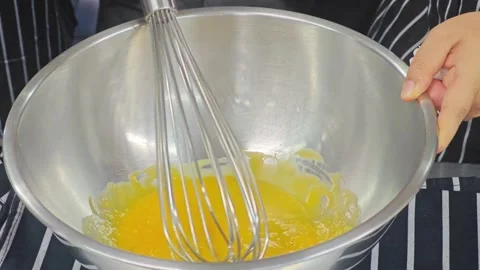 Whisked egg yolks inside a stainless steel mixing bowl. Stockbeeldmateriaal 339201367