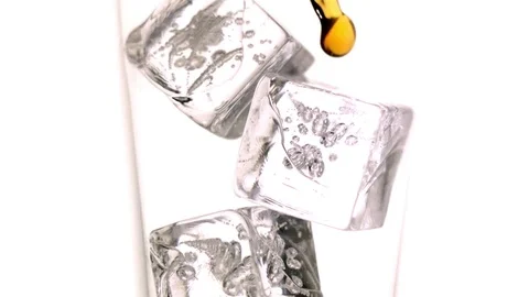 Whiskey being poured on the ice cubes in slow motion Stock Footage 81215150