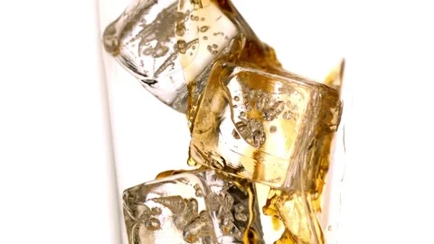 Whiskey being poured on the ice cubes in the glass in slow motion Video stock 81215720