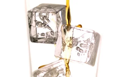Whiskey being poured over the ice cubes in glass in slow motion Stock Footage 81227341