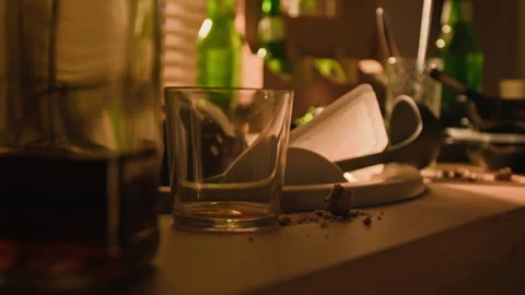Whiskey Bottle with Empty Glass on Table Depicting Alcoholism Stock Footage 344873176