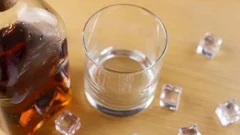 Ice cube falling into whisky glass – License Images – 11039807 ❘ StockFood