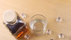 Ice cube falling into whisky glass – License Images – 11039807