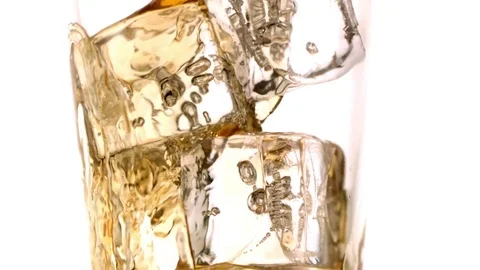 Whiskey flowing over the ice cubes in the glass in slow motion Stock Footage 81227073