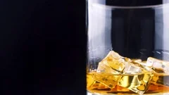 Ice cube falling into whisky glass – License Images – 11039807 ❘ StockFood