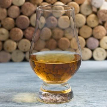 Whiskey in a glass in which corks are reflected Stock Photos