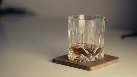 Whiskey Glass on White Table Stock Footage 86862978