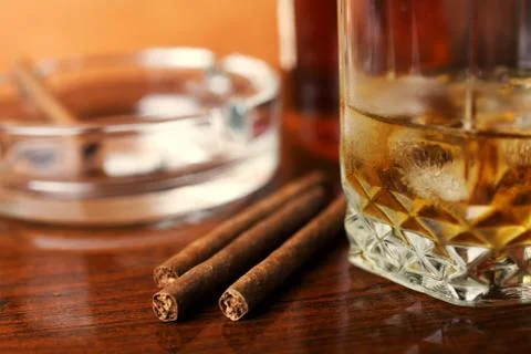 Whiskey with ice cigars on the table close-up, small depth of field, place fo Stock Photos