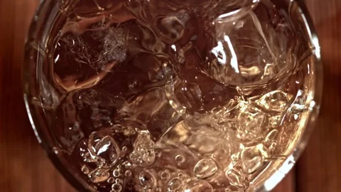Whiskey on Ice Rotating in a Glass with Floating Cubes and Bubbles 库存影片 331102747