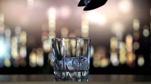 Whiskey is poured on ice in slow motion Stock Footage 129561271