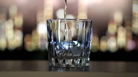 Whiskey is poured on ice in slow motion Stock Footage 129561595