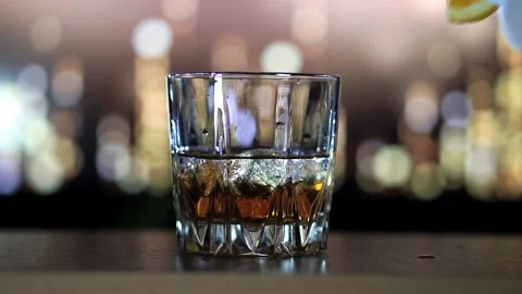 Whiskey is poured on ice in slow motion Stock Footage 129561792