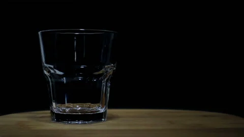 Whiskey is poured in slow motion into an empty glass Stock Footage 120905567