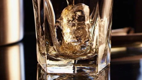 Whiskey pouring over Dancing Ice Cube GT3003 Stock Footage 123090611