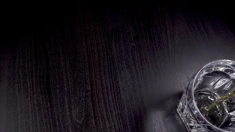 Whiskey pours into the glass on the table Stock Footage 87406497