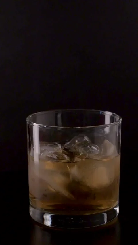 Whiskey on the Rocks Rotating on Turntable Isolated on Black Background Stock Footage 333645126
