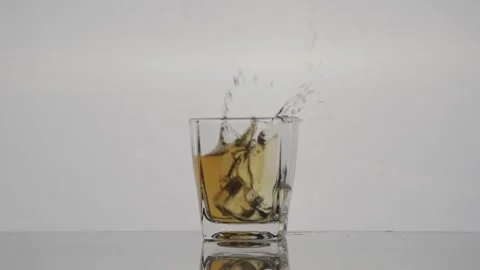 Whiskey on the Rocks: Slow-Motion Ice Cube Drop into the Glass Stock Footage 240219855
