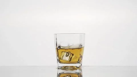 Whiskey on the Rocks: Slow-Motion Ice Cube Drop into the Glass Stock Footage 240224096