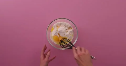 Whisking eggs, flour, baking powder, and sugar in a glass bowl Video stock 132148752