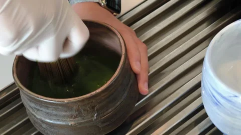 Whisking matcha powder while making matcha green tea Stock Footage 288452836