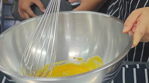 Whisking raw egg yolks in a stainless steel bowl. Видео 339201143