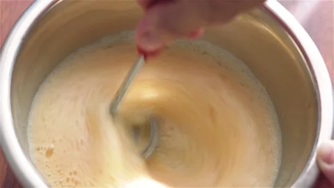 Whisking raw eggs making omelette in metal bowl close up Stock Footage 119432163
