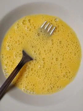 Whisking raw eggs for preparing breakfast ingredients Foto stock