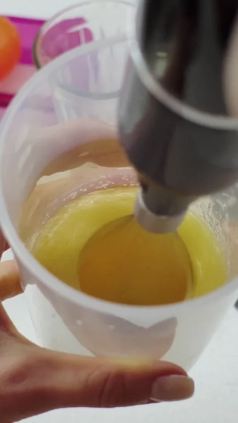 Whisking Yellow Liquid Beverage with Hand Mixer in Glass Beaker Stock-Footage 345206105