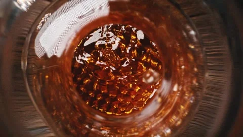 Whisky Decanter on the Rustical Table and Ice Cubes Dropped into Glass Stock Footage 271007302