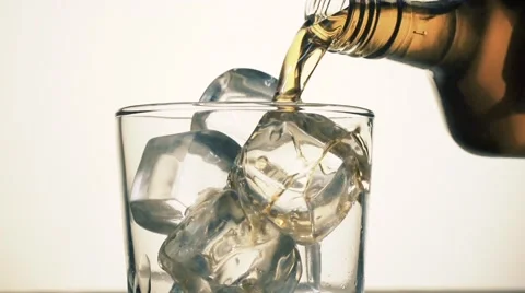 Whisky is poured over ice in slow motion; Stock Footage 55876952