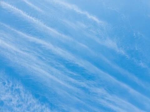 Whispering cloud formations dance gracefully over an endless azure expanse Stock Photos